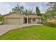 Charming single-Gathering home featuring a well-manicured lawn and an attached two-car garage at 2812 Ormandy Ct, Tampa, FL 33618