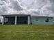 View of the house from the backyard showcasing the screened-in lanai and lush green lawn at 3190 Darius Ave, North Port, FL 34288