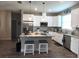 Modern kitchen with white cabinetry, granite countertops, stainless steel appliances, and breakfast bar at 3190 Darius Ave, North Port, FL 34288