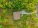 A high angle shot shows a well-maintained property with lush greenery surrounding a cozy home, driveway, and street view at 35150 Roth Ln, Dade City, FL 33525