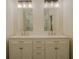 Bright bathroom with a double sink vanity, decorative mirrors, and a glass-enclosed shower at 35150 Roth Ln, Dade City, FL 33525