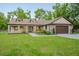 Beautiful home with covered porch, double door entry, mature trees, and green lawn at 35150 Roth Ln, Dade City, FL 33525