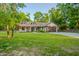 One-story home featuring mature landscaping, grass lawn, and a long driveway at 35150 Roth Ln, Dade City, FL 33525