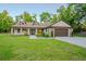 Exterior of stone and siding garage with a large concrete driveway at 35150 Roth Ln, Dade City, FL 33525