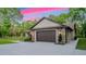 Exterior of stone and siding garage with a large concrete driveway at 35150 Roth Ln, Dade City, FL 33525