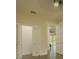 Hallway with bi-fold closet doors, passage doors, and views to the living room at 35150 Roth Ln, Dade City, FL 33525