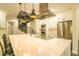 Contemporary kitchen with stainless steel appliances, white cabinetry, spacious island with seating, and spiral staircase access at 35150 Roth Ln, Dade City, FL 33525