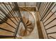 Unique wooden spiral staircase with black metal railings, offering a stylish transition between floors at 35150 Roth Ln, Dade City, FL 33525