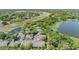 Aerial view of residential townhomes, ponds and landscape with lush trees near a lake at 3621 Country Pointe Pl, Palm Harbor, FL 34684