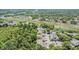 Aerial view of residential townhomes, pond, and landscape in a wooded and grassy area at 3621 Country Pointe Pl, Palm Harbor, FL 34684
