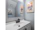 Bathroom vanity with white sink, matte black faucet, framed art, and a mirrored medicine cabinet at 3621 Country Pointe Pl, Palm Harbor, FL 34684