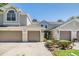 Exterior elevation of condo building, featuring multiple garages, and neatly trimmed landscaping at 3621 Country Pointe Pl, Palm Harbor, FL 34684