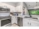 Bright kitchen featuring stainless steel appliances, white cabinets, and light countertops at 3621 Country Pointe Pl, Palm Harbor, FL 34684