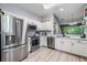 Bright kitchen featuring stainless steel appliances and white cabinets at 3621 Country Pointe Pl, Palm Harbor, FL 34684