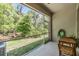 A screened lanai overlooking a green space with a table, chairs, and a garden hose at 3621 Country Pointe Pl, Palm Harbor, FL 34684