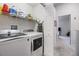 Well-organized laundry room featuring a washer and dryer, shelving, and storage for cleaning supplies at 3621 Country Pointe Pl, Palm Harbor, FL 34684