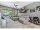 A bright living room features a large sectional, floating shelves, and sliding glass doors to the lanai at 3621 Country Pointe Pl, Palm Harbor, FL 34684