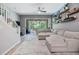 The living room features floating shelves, a large sectional, and sliding glass doors to the screened lanai at 3621 Country Pointe Pl, Palm Harbor, FL 34684