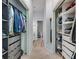 A walk-in closet featuring custom storage with multiple doors and a hallway leading to a half bathroom at 3621 Country Pointe Pl, Palm Harbor, FL 34684