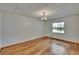 Sunlit living room featuring hardwood floors, large window with lake view, and pendant lighting at 3821 N Oak Dr # J31, Tampa, FL 33611
