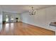 Spacious living room with hardwood flooring, statement chandelier, and view of the lake at 3821 N Oak Dr # J31, Tampa, FL 33611