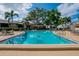 Community pool with lounge chairs and tables in manicured landscaping at 3821 N Oak Dr # J31, Tampa, FL 33611