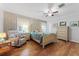 Bright bedroom featuring patterned wallpaper, a ceiling fan, hardwood floors, and calming decor at 4214 W Beach Park Dr, Tampa, FL 33609