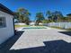 Backyard featuring a pool, stone firepit, gray-bricked patio, and well-maintained lawn at 4619 Helena Ne St, St Petersburg, FL 33703