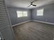 Neutral bedroom with modern fan, wood-look floors, and windows at 4619 Helena Ne St, St Petersburg, FL 33703