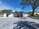 Charming single-story home with a paved driveway and well-maintained landscaping under a blue sky at 4619 Helena Ne St, St Petersburg, FL 33703