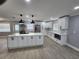 Open kitchen layout featuring an island, white cabinets, stainless steel appliances, and modern pendant lighting at 4619 Helena Ne St, St Petersburg, FL 33703
