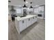 Modern kitchen with stainless steel appliances, large island, white cabinets, and stylish pendant lighting at 4619 Helena Ne St, St Petersburg, FL 33703