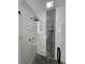 Modern shower featuring sleek marble tile, stylish dark accents, and pebble floor and mosaic wall at 4619 Helena Ne St, St Petersburg, FL 33703
