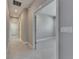 Neutral hallway with tile flooring and multiple doorways showcases the home's layout and accessibility to various rooms at 4734 Avila Lakes Dr, Wimauma, FL 33598