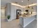 Bright, modern kitchen with stainless steel appliances, pendant lighting, and white cabinetry at 4734 Avila Lakes Dr, Wimauma, FL 33598