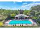 Aerial view of a community pool with lounge chairs surrounded by trees and a fence at 4920 Pond Ridge Dr, Riverview, FL 33578
