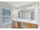 Bright bathroom with double vanity, large mirror, and natural light from the window at 4920 Pond Ridge Dr, Riverview, FL 33578