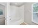 Bathroom featuring a bathtub with white tile surround and a window to let in natural light at 4920 Pond Ridge Dr, Riverview, FL 33578