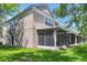 Back exterior view of home with large lawn and screened in porch, perfect for outdoor enjoyment at 4920 Pond Ridge Dr, Riverview, FL 33578