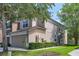 Beige townhome featuring an attached two-car garage and well-maintained landscaping at 4920 Pond Ridge Dr, Riverview, FL 33578