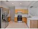 Bright kitchen with stainless steel refrigerator, tile flooring, and wood cabinetry at 4920 Pond Ridge Dr, Riverview, FL 33578