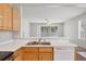 Close-up of kitchen featuring oak cabinets, stainless steel appliances, and open access to the living room at 4920 Pond Ridge Dr, Riverview, FL 33578