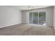 Spacious living room with carpet flooring and sliding glass doors to the outside screened patio at 4920 Pond Ridge Dr, Riverview, FL 33578