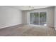 Neutral living room featuring carpeting and sliding doors to a screened lanai at 4920 Pond Ridge Dr, Riverview, FL 33578