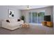 Bright living room features a comfortable couch, ceiling fan, and sliding glass doors to outdoor patio at 4920 Pond Ridge Dr, Riverview, FL 33578