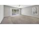 Neutral living room featuring carpeting and sliding doors to a screened lanai at 4920 Pond Ridge Dr, Riverview, FL 33578