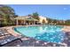 Community pool with a covered cabana and lounge chairs; view of townhouses at 4920 Pond Ridge Dr, Riverview, FL 33578