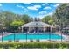 Community pool featuring a covered cabana, seating, and manicured greenery around fence at 4920 Pond Ridge Dr, Riverview, FL 33578