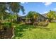 Well-maintained backyard with lush lawn, landscaping, and view of the screened lanai at 506 Crystal Grove Blvd, Lutz, FL 33548