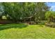 A lush green backyard featuring a charming wooden gazebo and mature trees, perfect for outdoor relaxation at 506 Crystal Grove Blvd, Lutz, FL 33548